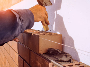 man building a brick wall